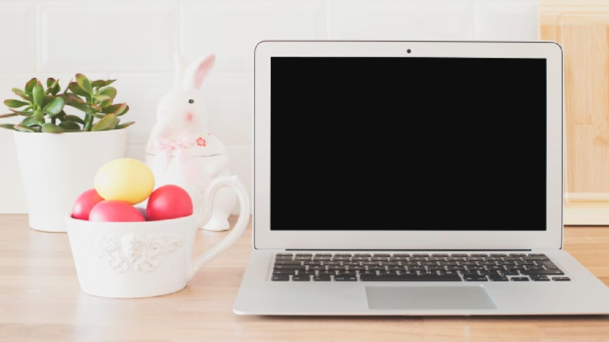 Easter-themed workspace with a laptop, colourful eggs, and plant, symbolising a reset for business and fresh financial planning
