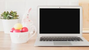 Easter-themed workspace with a laptop, colourful eggs, and plant, symbolising a reset for business and fresh financial planning